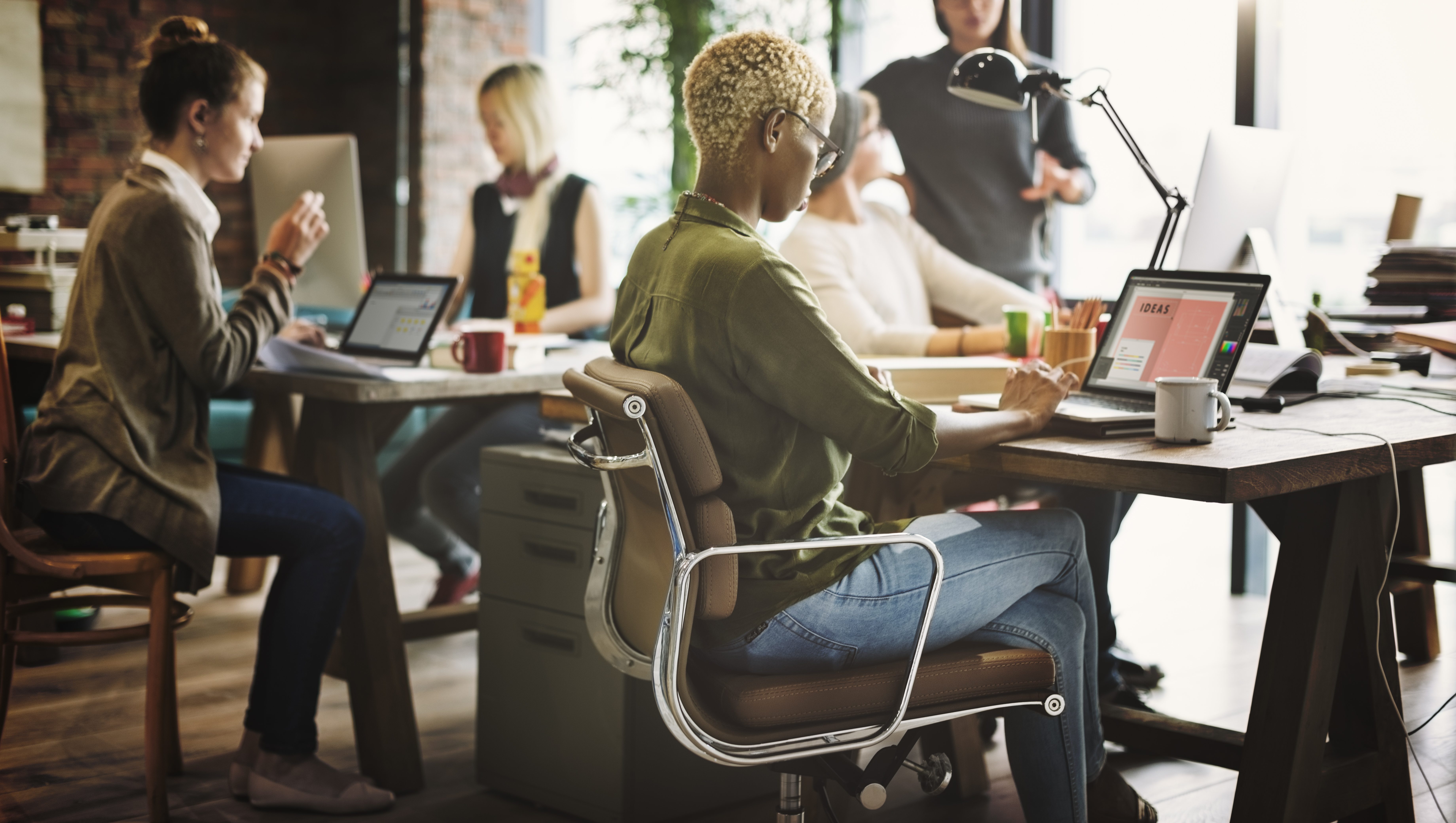 People working on laptops and collaborating in a modern office.